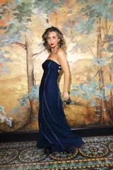 Vestido largo strapless de encaje negro con transparencias y espalda descubierta con tiras cruzadas, de corte entallado y falda de caída suelta.