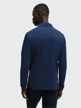 Remera polo de piqué de algodón color beige, de manga larga y corte entallado.