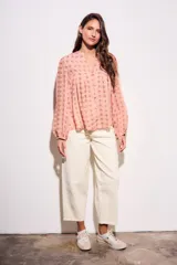 Blusa de corte oversize con estampado de abanicos, cuello redondo con pequeña abertura frontal, cierre de botones y mangas largas con puños elásticos.