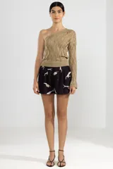 Shorts negros con estampado de sirenas blancas, cintura elastizada, pliegues al frente y bolsillos laterales.