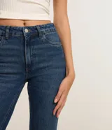 Pantalón de jean modelo flare cropped, de tiro alto, con bolsillos funcionales y cintura con trabillas. Presenta un corte ceñido en caderas y muslos con una ligera apertura acampanada desde la rodilla y ruedo deshilachado.