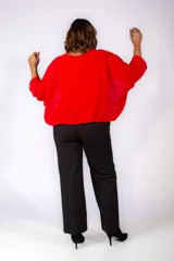 Blusa roja de corte holgado con mangas tres cuartos abullonadas y cuello redondo.