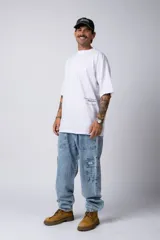 Remera blanca de corte oversize con cuello redondo y mangas cortas. Presenta un pequeño estampado tipográfico en la parte inferior frontal y un diseño gráfico de mayor tamaño en la espalda.