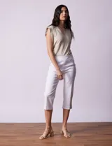 Pantalón capri blanco de algodón denim con pretina ancha elastizada, bolsillos delanteros simulados y bolsillos traseros aplicados.