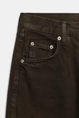 Jeans de tiro medio con corte baggy y pierna relajada. Presenta diseño de cinco bolsillos, cierre frontal con cremallera y botón, y bajo acabado con vuelta.