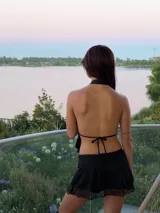 Minifalda de encaje negro con diseño semitransparente y short interno incorporado para mayor comodidad.