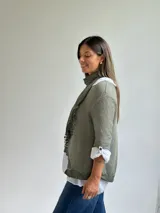 Sweater de punto fino en color verde oliva, con diseño de cuello redondo y mangas tres cuartos. Incluye un pañuelo a juego con detalles de encaje en los bordes, que puede utilizarse como accesorio para el cuello.