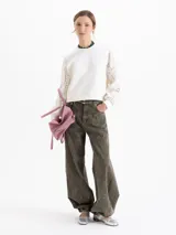 Buzo de calce regular con cuerpo de tela lisa y mangas largas de tejido calado con textura. Presenta escote redondo y puños ajustados.