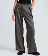 Pantalón de vestir estilo sastre, de corte recto y tiro medio. Presenta pliegues discretos en la parte delantera, perneras amplias y cierre clásico. Incluye un cinturón fino con hebilla metálica.