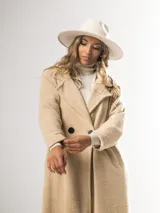 Tapado clásico color beige, con solapas de muesca, doble botonadura y bolsillos laterales.