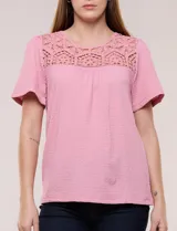Blusa blanca de textura gofrada, de corte recto y semi holgado, con mangas cortas y escote redondo adornado con un canesú frontal en crochet calado.