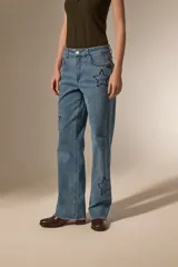 Pantalon de jean azul de corte recto y calce medio, con bordados de estrellas y detalles de pequeñas tachas.