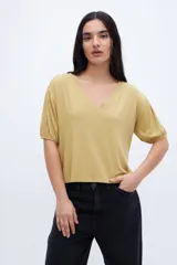 Remera color crudo con textura de tejido y escote en V, con mangas cortas abullonadas.