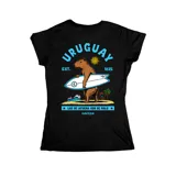 Remera negra entallada de manga corta con estampado gráfico en la espalda que muestra un carpincho surfista con la inscripción 'Uruguay' y la frase 'Los de afuera son de palo'.