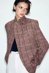 Blazer de lana con diseño de cuadros, cuello subido, manga larga, bolsillos delanteros y cierre frontal cruzado con un botón.