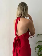 Conjunto de dos piezas color rojo. Incluye un top halter con argolla decorativa en el escote y lazo ajustable en el contorno. La falda es larga, recta y de diseño cruzado regulable.