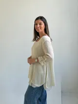 Sweater de punto color beige, de corte amplio y holgado, con escote redondo y mangas largas con presillas para arremangar.