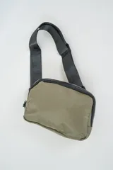 Bandolera color verde militar con cierre de cremallera y correa ajustable de tela negra.