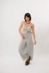 Musculosa negra con escote en V, breteles finos regulables y doble volado frontal con pespuntes.