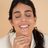 Medio aro de oro 18k con perla de cultivo colgante. Diseño minimalista y elegante.