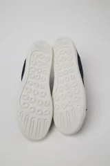 Championes Camper modelo Touring de diseño minimalista, color azul marino con suela de goma blanca. Presentan cierre de cordones al tono y el logo de la marca grabado en el lateral de la suela.