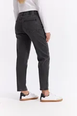 Jean estilo mom de tiro medio y corte recto con leve holgura, en color gris oscuro con efecto lavado. Cuenta con cierre frontal y bolsillos laterales y traseros.