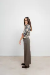 Pantalón de corte wide leg en color marrón, con tiro medio, cierre frontal con botón metálico y costuras visibles a contratono.