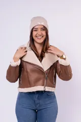 Campera tipo gamulán de cuerina color beige con interior y detalles en corderito blanco. Presenta corte biker, cierre frontal diagonal, bolsillos laterales con cierre y puños con vuelta de corderito.