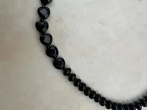 Collar de piedras naturales de ágata talladas en forma de corazón, con tonos verdes y violáceos, unidos por una fina cadena metálica.