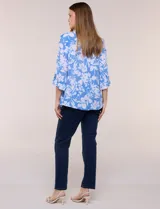 Blusa liviana de cuello mao con estampado floral en tonos azul y blanco, manga tres cuartos con presilla para arremangar, bolsillos frontales con solapa y cierre de botones nacarados.