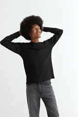 Remera de manga larga, color negro, con cuello redondo y corte recto.