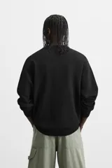 Jersey de punto de tacto suave con diseño de rayas horizontales anchas en color rosa claro y marrón oscuro. Presenta cuello redondo, manga larga y terminaciones en rib.