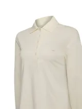 Chomba de manga larga color beige, confeccionada en piqué de algodón pima. Presenta cuello camisero clásico, tapeta con botones tono a tono y pequeño parche bordado en el pecho.