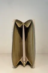 Billetera de charol color cereza con textura tipo cocodrilo y cierre perimetral con cremallera.