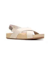 Sandalias planas de cuero color beige claro con tiras cruzadas en el empeine y tira trasera con ajuste elástico metalizado.