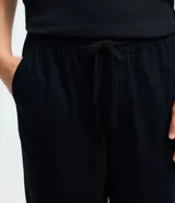 Pantalón de sarga corte relaxed, color negro, con cintura elástica y lazo de ajuste. Cuenta con bolsillos laterales y diseño liso.