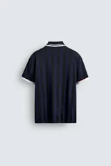 Polo de corte relajado confeccionado en tejido técnico, con diseño de rayas verticales en tonos azul marino y negro. Presenta cuello solapa con abertura frontal y detalles de rib en contraste en cuello y mangas. Incluye estampado frontal con el número 98 y la inscripción France, además de una etiqueta aplicada en el ruedo inferior.