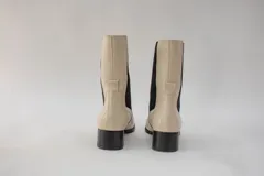 Botas de cuero color beige con elásticos laterales negros, taco cuadrado y punta cuadrada.