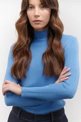 Polera de tejido morley color azul, con cuello alto y mangas largas, de corte ajustado al cuerpo.