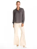 Camisa de satén color celeste, con cuello clásico, cierre frontal con botones y mangas largas con puños abotonados.