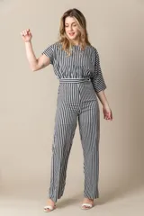 Mono largo a rayas verticales blancas y negras con mangas cortas asimétricas y cierre invisible en la espalda.