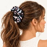 Colita de pelo estampada con diseño fruncido, ideal para recoger el cabello o usar como accesorio en la muñeca.