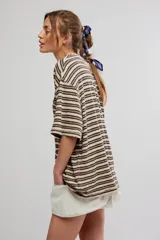 Remera oversize de manga corta a rayas celestes y blancas, con cuello redondo y un bolsillo aplicado en el pecho.