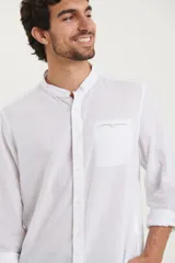 Camisa de cuello mao y manga larga, confeccionada en una mezcla de lino y algodón. Presenta un diseño de corte recto con botones en tono natural y un bolsillo pequeño en el pecho.