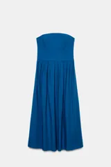 Vestido midi azul eléctrico, sin mangas y con escote recto (strapless). El corpiño es ajustado y la falda tiene pliegues amplios que le dan volumen.