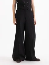 Pantalón Capri sastrero de tiro alto y silueta wide leg, confeccionado en mezcla de poliéster, viscosa y elastano. Presenta pinzas de entalle, pliegues planchados en las piernas y bolsillos con detalle de volados en los laterales.