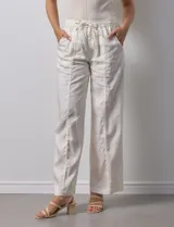 Pantalón palazzo color crudo de lyocell marca Nanette, con pretina elastizada, lazo de ajuste y bolsillos delanteros.