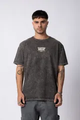Remera de algodón con efecto lavado ácido en color gris oscuro. Presenta cuello redondo, mangas cortas y un diseño estampado en el pecho con la frase 'Coffee Break'.