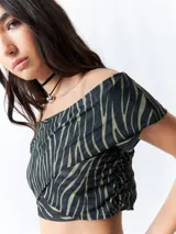 Top negro con estampado floral, escote off-shoulder, corte cruzado y mangas cortas.