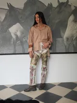 Pantalón de cuero color beige con estampado artístico.
